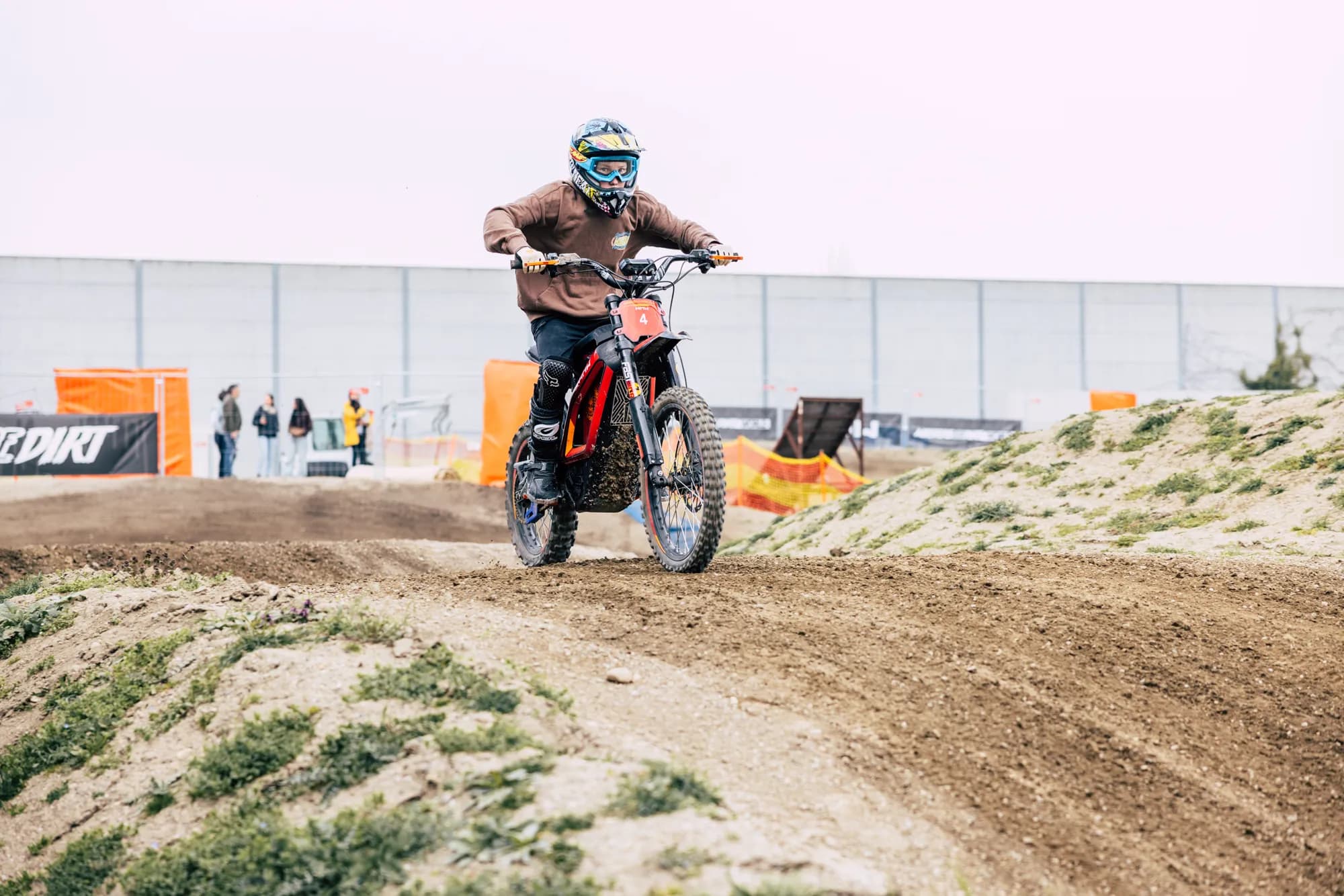 Rider on an electric motocross bike cresting a berm on the adult track